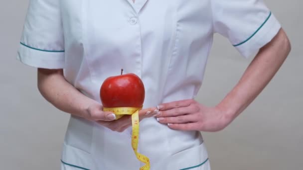 Nutriční lékař zdravý životní styl koncept - drží organické červené jablko a měřicí pásku — Stock video