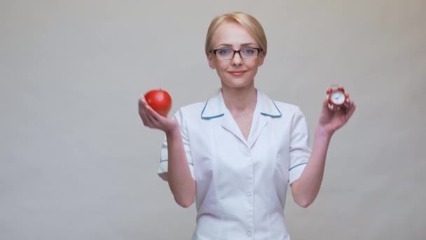 Concepto de estilo de vida saludable médico nutricionista - la celebración de manzana roja orgánica y despertador — Vídeo de stock