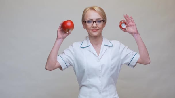 Nutriční lékař zdravý životní styl koncept - držení organické červené jablko a budík — Stock video