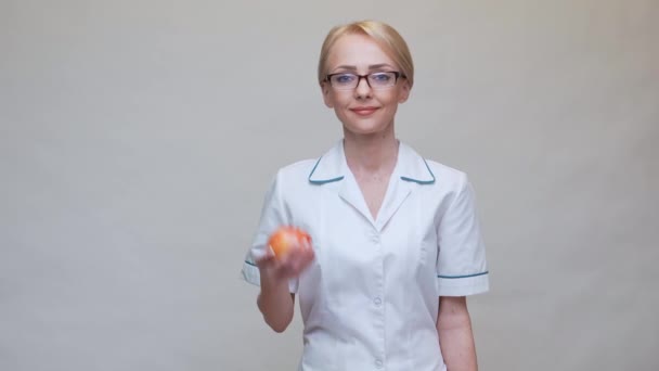 Nutritionist doctor healthy lifestyle concept - holding organic red apple and jar of vitamin pills — Stock Video