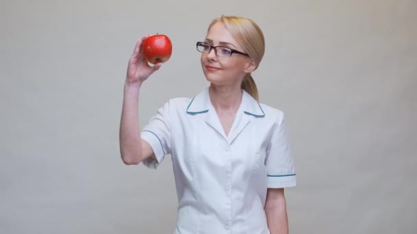 Концепция здорового образа жизни врача-диетолога - проведение красного яблока и лекарства или витаминов — стоковое видео