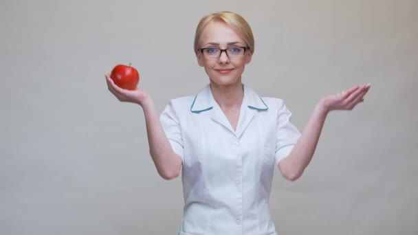 Nutricionista médico concepto de estilo de vida saludable - la celebración de manzana roja y medicamentos o píldoras vitamínicas — Vídeo de stock