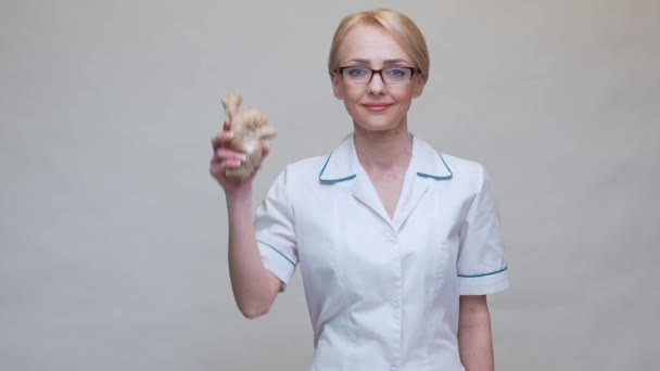 Dietetyk lekarz zdrowy styl życia koncepcja - trzymając imbir korzeń i taśmę pomiarową — Wideo stockowe