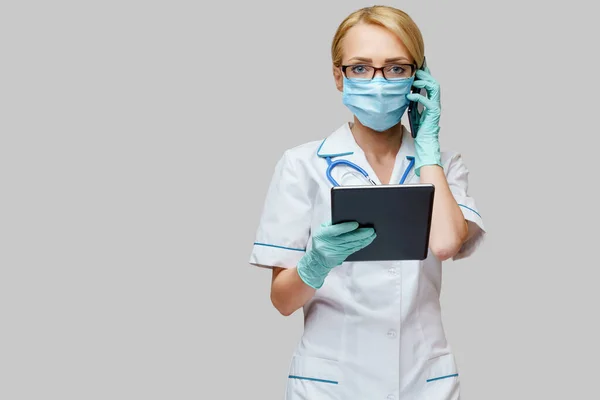 보호용 마스크를 쓰고 장갑을 끼는 알약 pc 와 휴대 전화를 착용하는 의사 간호사 — 스톡 사진