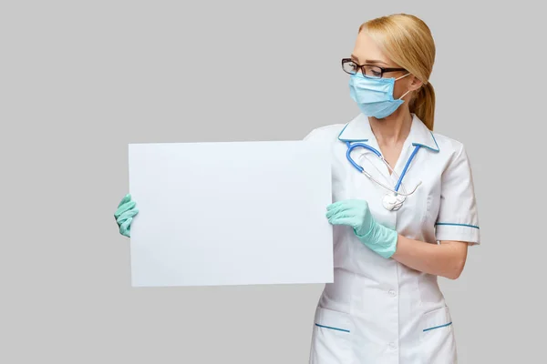 Doctor or woman nurse showing blank empty sign with copy space — Stock Photo, Image