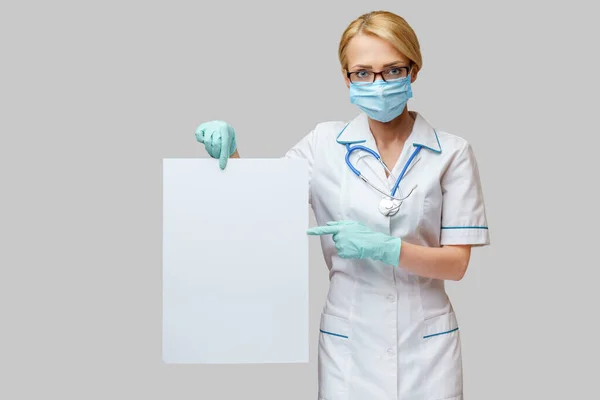 Doctor or woman nurse showing blank empty sign with copy space — Stock Photo, Image