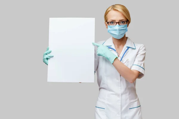 Doctor or woman nurse showing blank empty sign with copy space — Stock Photo, Image