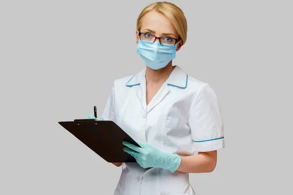 Doctor or woman nurse holding plane table and pen — Stock Photo, Image