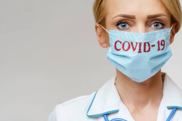 Medico donna con stetoscopio con maschera protettiva e guanti in lattice su sfondo grigio chiaro — Foto Stock