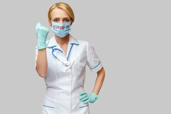 Médecin infirmière femme portant un masque de protection et des gants en caoutchouc ou en latex - oui geste gagnant — Photo