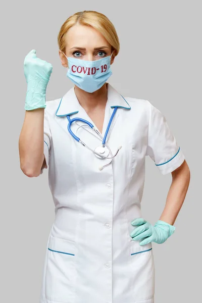 Врач медсестра женщина в защитной маске и резиновых или латексных перчатках - да выиграть жест — стоковое фото