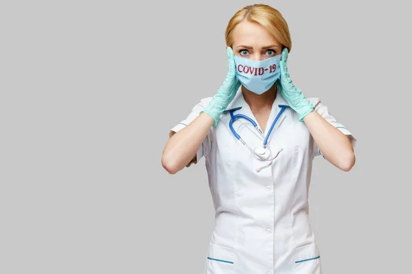 Médecin infirmière femme portant un masque protecteur et des gants en caoutchouc ou en latex - maux de tête et stress — Photo