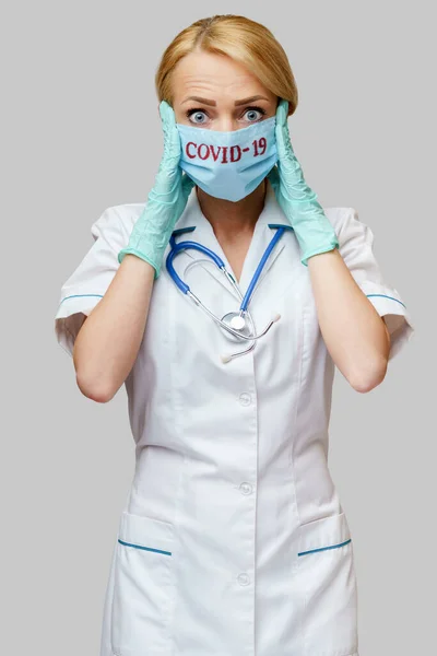 Врач медсестра женщина в защитной маске и резиновых или латексных перчатках - головная боль и стресс — стоковое фото