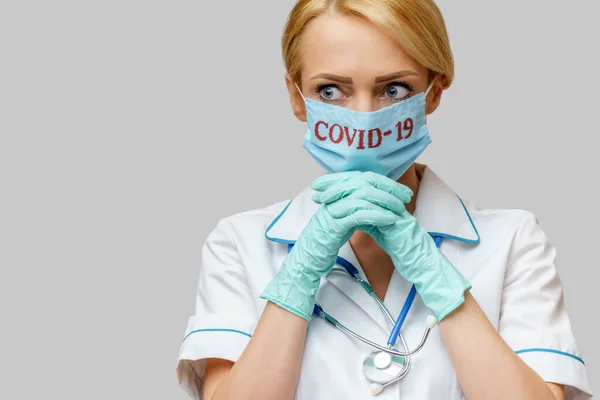 Врач медсестра женщина в защитной маске и латексных перчатках - молиться без надежды жест — стоковое фото