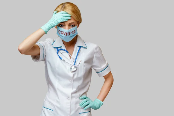 Medico infermiere donna con maschera protettiva e guanti di gomma o lattice mal di testa e stress — Foto Stock