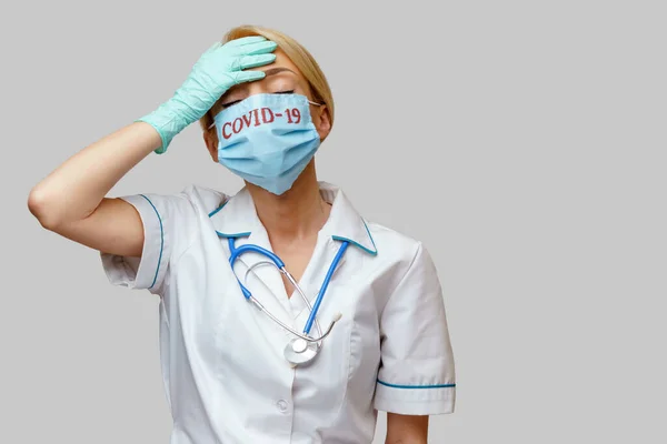 Médecin infirmière femme portant un masque protecteur et des gants en caoutchouc ou en latex - maux de tête et stress — Photo