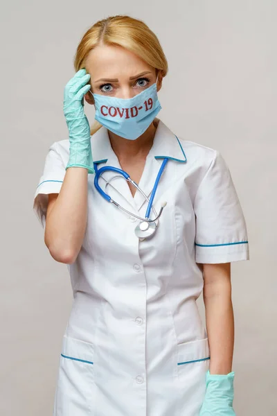 Medico infermiere donna con maschera protettiva e guanti di gomma o lattice mal di testa e stress — Foto Stock