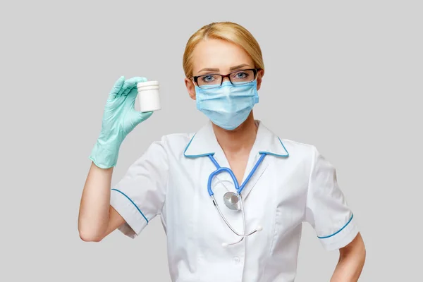 Verpleegkundige verpleegkundige vrouw met beschermend masker en rubber of latex handschoenen - met blik pillen — Stockfoto