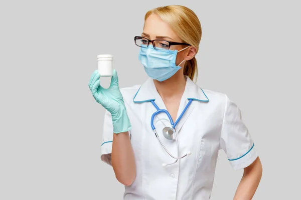 医生护士，戴着防护面罩，戴着橡胶或乳胶手套的妇女-- --装有药丸罐 — 图库照片