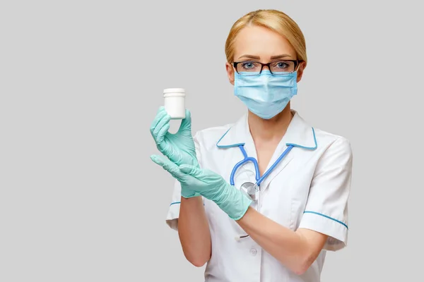 Verpleegkundige verpleegkundige vrouw met beschermend masker en rubber of latex handschoenen - met blik pillen — Stockfoto