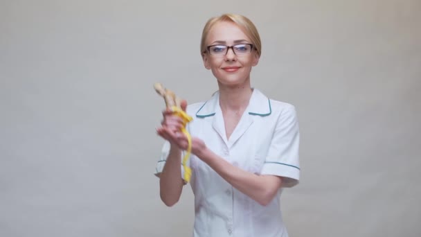Nutritionist doctor healthy lifestyle concept - holding ginger root and measuring tape — Stock Video