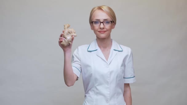 Nutritionist doctor healthy lifestyle concept - holding ginger root and jar of or vitamine pills — Stock Video