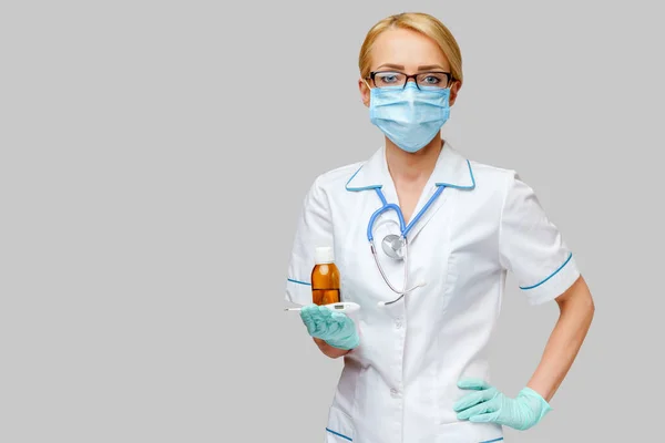 보호용 마스크와 고무나 라텍스 장갑을 끼고 있는 의사 간호사, 의약품 과 온도계가 들어 있는 깡통 — 스톡 사진