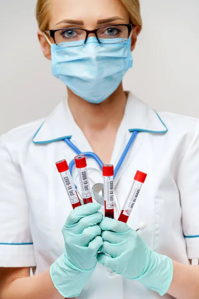 Orvos nővér nő visel védő maszk és kesztyű - gazdaság vírus vérvizsgálat cső — Stock Fotó