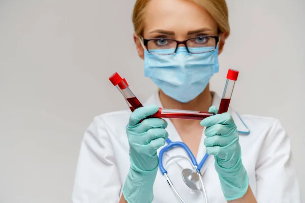 Medische arts verpleegkundige vrouw met beschermende masker en handschoenen - houden virus bloed reageerbuis — Stockfoto