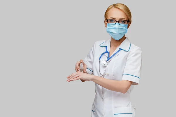 보호용 마스크를 착용하고 있는 의사의 간호사 - 사죄하는 기도나 젤 병을 들고 있는 병 — 스톡 사진