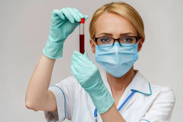 Medische arts verpleegkundige vrouw met beschermende masker en handschoenen - houden virus bloed reageerbuis — Stockfoto