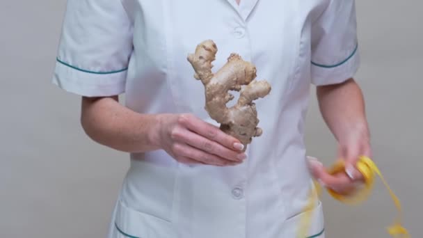 Ernährungswissenschaftler Arzt Konzept eines gesunden Lebensstils - Ingwerwurzel und Maßband in der Hand — Stockvideo