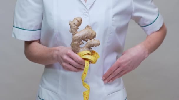 Nutrizionista medico sano concetto di stile di vita - tenendo radice di zenzero e metro a nastro — Video Stock