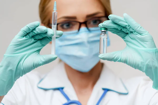 Salud trabajadora médica mujer sosteniendo vacuna y jeringa —  Fotos de Stock