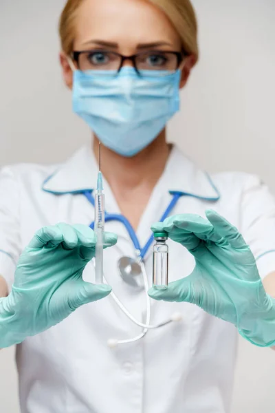 Salud trabajadora médica mujer sosteniendo vacuna y jeringa —  Fotos de Stock