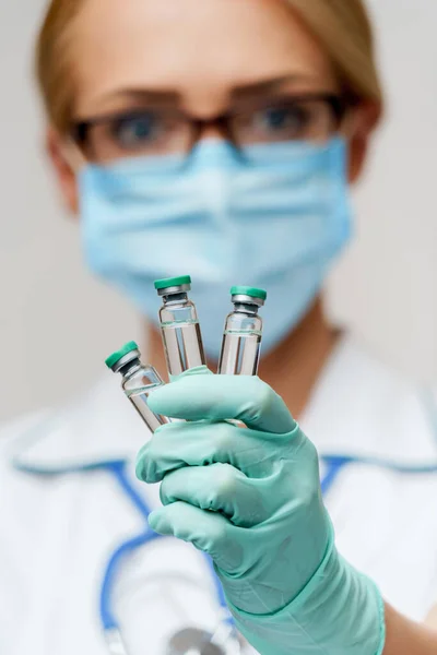Sağlık çalışanı kadın elinde aşı tüpü tutuyor. — Stok fotoğraf