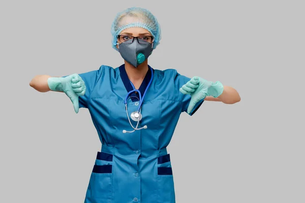 Γυναίκα γιατρός με στηθοσκόπιο φορώντας προστατευτική μάσκα και γάντια λάτεξ σε ανοιχτό γκρι φόντο — Φωτογραφία Αρχείου