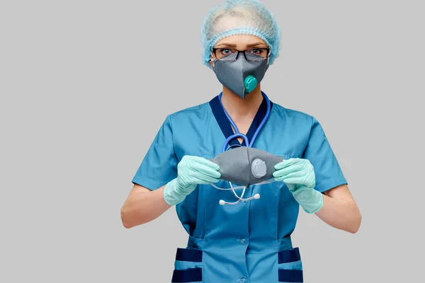 ライトグレーの背景に保護マスクとラテックス手袋を身に着けている聴診器を持つ女性医師 — ストック写真