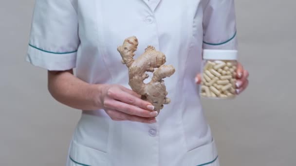 Nutriční lékař zdravý životní styl koncept - držení zázvoru kořen a sklenice nebo vitamíny pilulky — Stock video