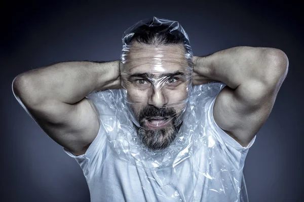 Portrait of a man with a beard and his face wrapped in a plastic — Stock Photo, Image