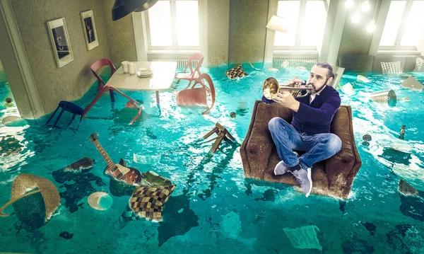 Man plays the trumpet in a floating chair in a completely floode — Stock Photo, Image