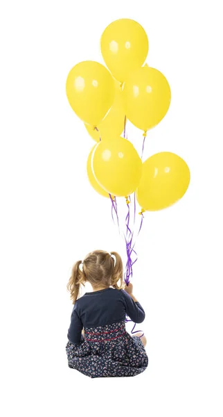 Menina de 3 anos segurando um grupo de balões amarelos . — Fotografia de Stock