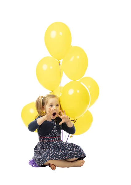 Little girl sitting with balloons, playful and surprised express — 스톡 사진