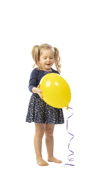 Stående liten flicka håller en gul ballong — Stockfoto