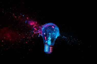 Tungsten filament ampulünün gerçek patlaması. Yüksek hızlı fotoğrafçılık. Siyah arka plan. Eskimiş enerji, kriz, kırılganlık kavramı.