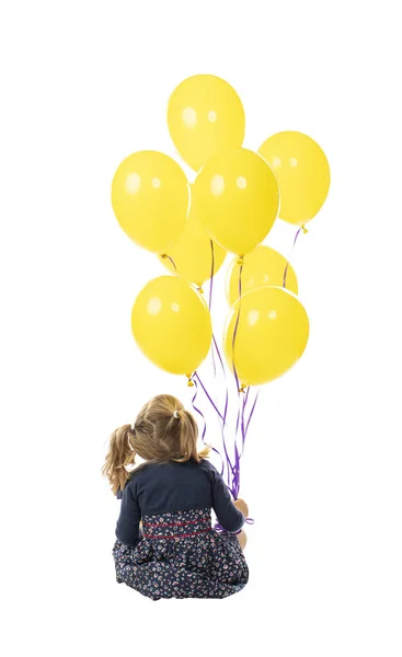 Сидяча Маленька Дівчинка Тримає Жовті Кульки Руці Ізольовані Білому Тлі — стокове фото