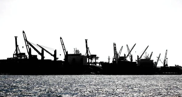 Sziluettjét a kikötő daruk — Stock Fotó