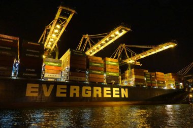 KAOHSIUNG, TAIWAN -- 2 Haziran 2019: Kaohsiung Limanı 'ndaki gemilere hava karardığında konteynırlar yükleniyor