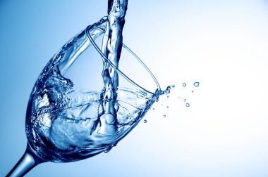 Cam üzerinde mavi arka plan, içine su dökme yakın çekim