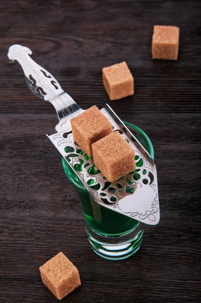 Close-up Absinthe com um cubo de açúcar e colher de absinto no woode — Fotografia de Stock